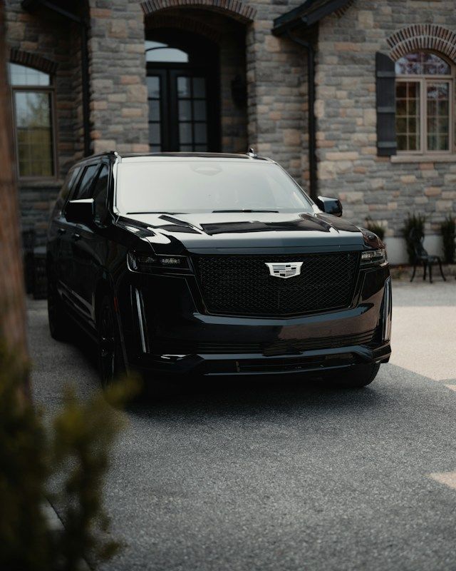 A black SUV parked in front of a stone house